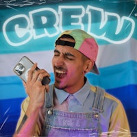 a man in overalls is singing in front of a flag with the word crew